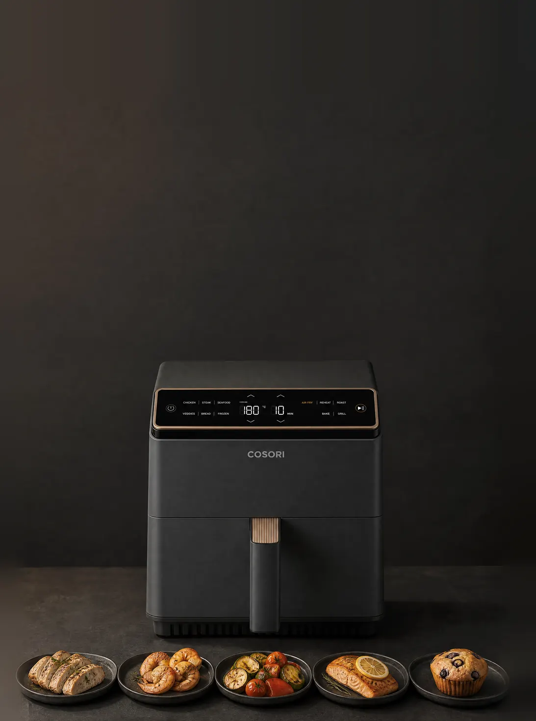Аэрогриль Dual Blaze на тёмном столе, перед ним пять приготовленных блюд